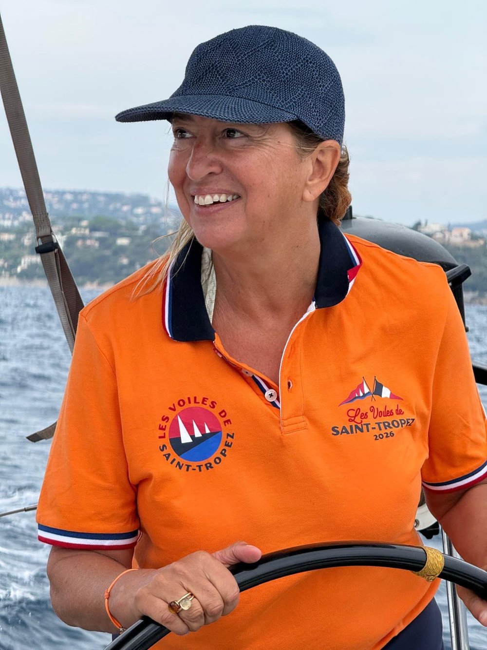 Juliette Kopp souriante à la barre de son voilier